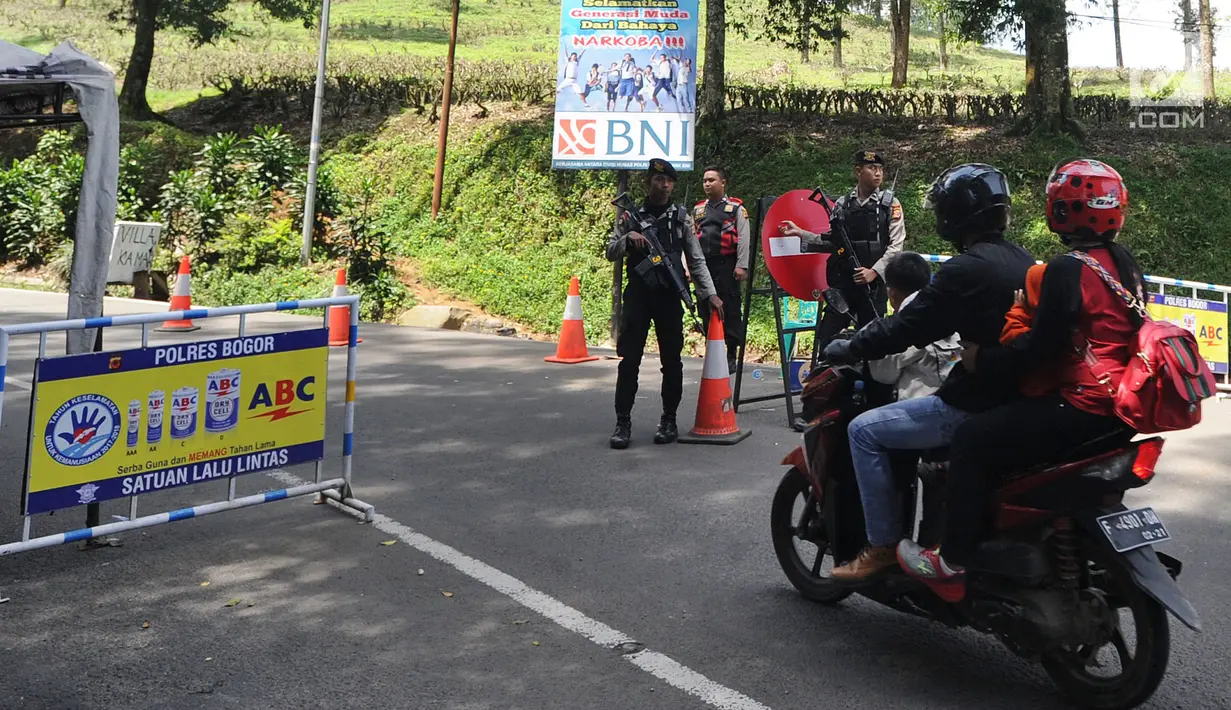 Pengendara motor melawati jalan yan dijaga polisi di di kawasan Puncak, Bogor (29/03). Akibat terjadi longsor di Ciloto, sejumlah jalan di kawasan puncak ditutup. (Merdeka.com/Arie Basuki)