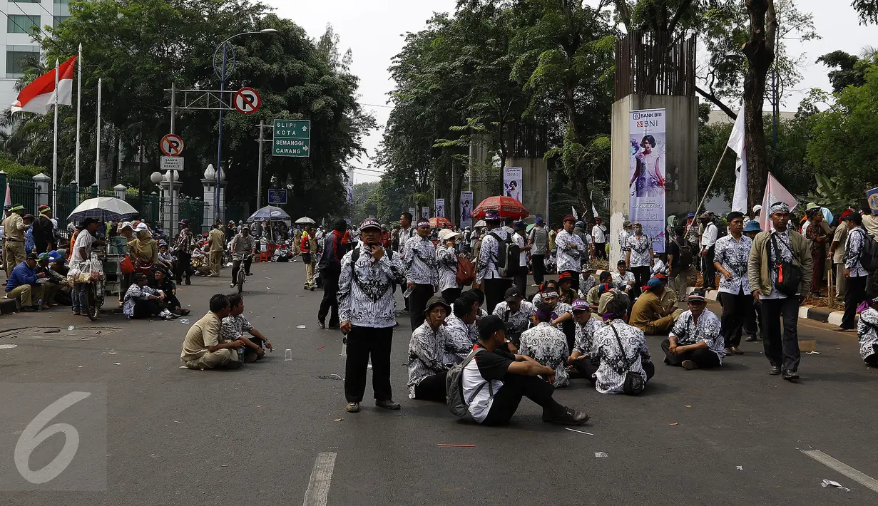 Ribuan guru honorer dan anggota PGRI bertahan di Jl. Asia Afrika, Senayan, Jakarta, Selasa (15/9/2015). Sebelumnya guru honorer sempat melakukan unjuk rasa di depan gedung DPR/MPR RI menuntut status honorer K2 menjadi PNS. (Liputan6.com/Yoppy Renato)