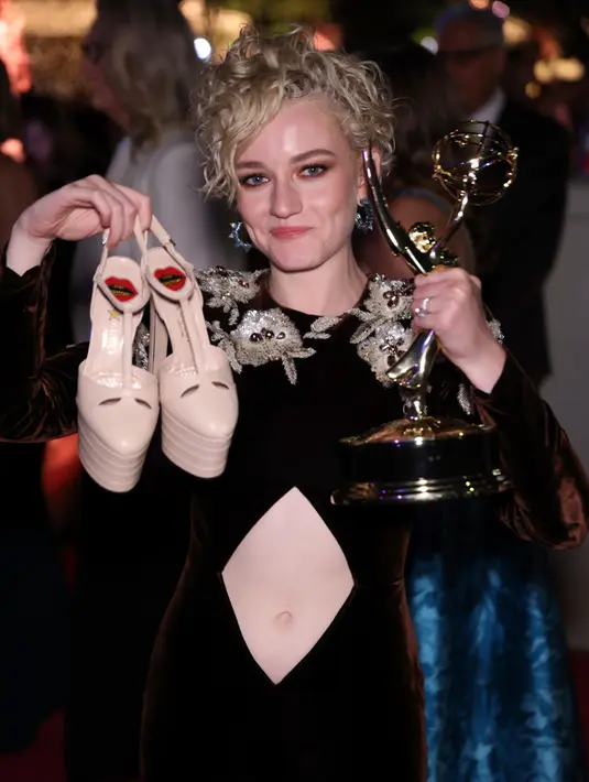 Julia Garner menunjukkan piala penghargaan kategori aktris pendukung terbaik dalam serial drama pada ajang Primetime Emmy Awards ke-74 di Microsoft Theater, Los Angeles, Amerika Serikat, 12 September 2022. Julia Garner melepaskan sepatu hak tingginya dan mengangkat penghargaannya dengan bangga. (Photo by Willy Sanjuan/Invision/AP)