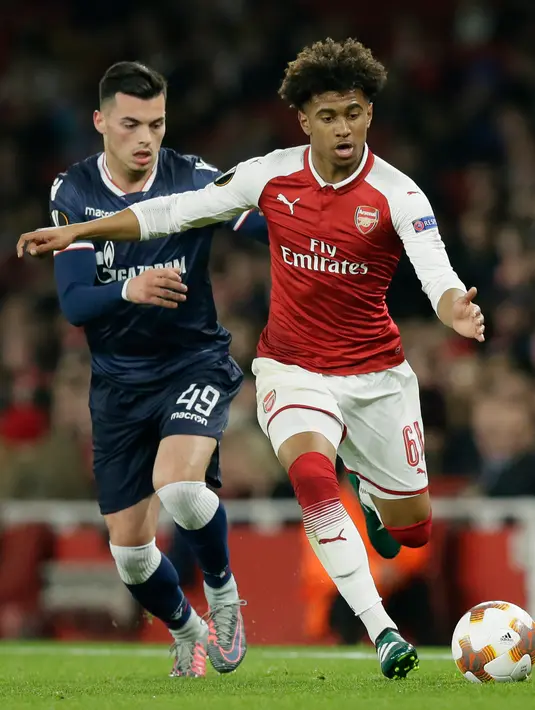 Pemain Arsenal, Reiss Nelson berebut bola dengan pemain Red Star Belgrade, Nemanja Radonjic pada penyisihan Grup H Liga Europa di Emirates Stadium, Jumat (3/11). The Gunners ditahan imbang tanpa gol oleh tim tamu. (AP /Tim Ireland)