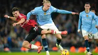 Pemain Manchester City, Erling Haaland, tengah, berebut bola dengan pemain Manchester United, Manuel Ugarte, selama pertandingan Liga Primer Inggris antara Manchester City dan Manchester United di Stadion Etihad, Manchester, Minggu, 15 Desember 2024. (Foto AP/Dave Thompson)
