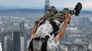 Penerjun Australia Jon McGregor melompat dari dek terbuka Menara Kuala Lumpur saat International Tower Jump, Kuala Lumpur, Malaysia, 3 Februari 2023. Lebih dari 100 penerjun melompat dari Menara Kuala Lumpur setinggi 300 meter yang terkenal tersebut. (MOHD RASFAN/AFP)