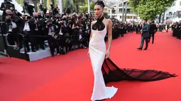 Model AS, Bella Hadid tiba untuk upacara pembukaan dan pemutaran film "Annette" di Festival Film Cannes ke-74 di Prancis, Selasa (6/7/2021). Gaun Bella Hadid menampilkan garis halter neck dengan syal terbuat dari tulle tipis yang sama dengan ekor panjang, dililitkan di lehernya. (Valery HACHE/AFP)