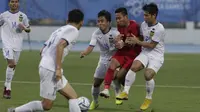 Gelandang Timnas Indonesia U-22, Evan Dimas, terjepit saat melawan Laos U-22 pada laga SEA Games 2019 di Stadion City of Imus Grandstand, Manila, Kamis (5/12). Indonesia menang 4-0 atas Laos. (Bola.com/M Iqbal Ichsan)