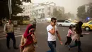 Sempat terjadi kepanikan, beberapa warga Iran terlihat berjalan di tengah-tengah debu pasir di Teheran, Iran, (2/6/2014). (AFP PHOTO/ISNA/Hamidreza Dastjerdi)