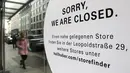 Seorang wanita berjalan di depan toko pakaian tradisional Bavaria yang tutup di pusat kota di Munich, Jerman, Selasa (23/3/2021). Jerman memperpanjang tindakan pengunciannya sebulan lagi. (AP Photo/Matthias Schrader)