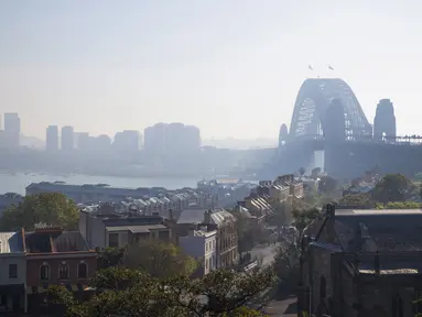 Jembatan Sydney Harbour terlihat diselimuti asap saat kabut asap menyelimuti Sydney Harbour yang indah di Australia, Rabu (13/9/2023). (Steve CHRISTO / AFP)