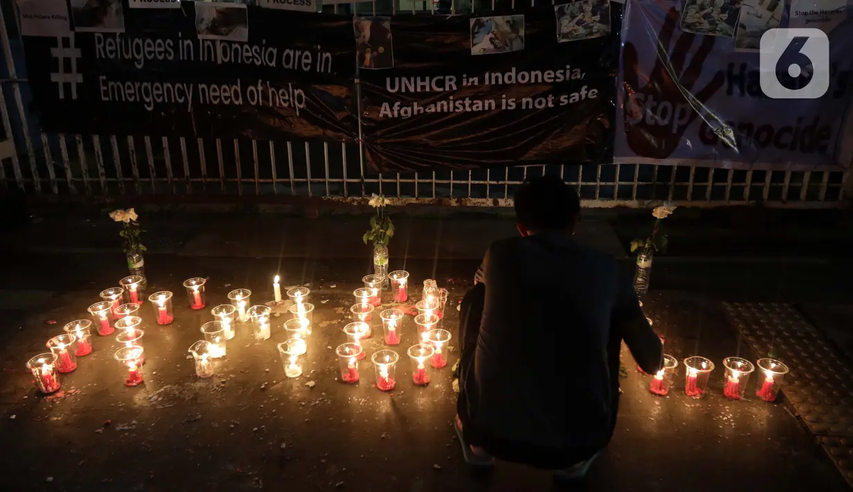 Seorang pencari suaka menyalakan lilin membentuk nama kota di Afghanistan saat aksi keprihatinan yang digelar di depan kantor UNHCR, Jakarta, Selasa (11/5/2021). Mereka prihatin atas peristiwa serangan bom yang menewaskan puluhan siswi di Kabul, Afghanistan. (Liputan6.com/Helmi Fithriansyah)
