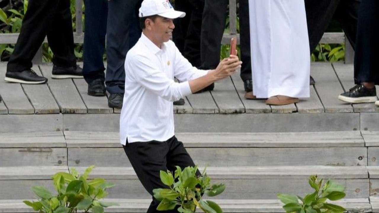 Jokowi lantas mengambil posisi untuk memotret Barbara Pompili. Tak hanya sekali, Jokowi tampak memotret Barbara dengan beberapa angle.&nbsp;Foto: Sonny Tumbelaka/Pool/AFP