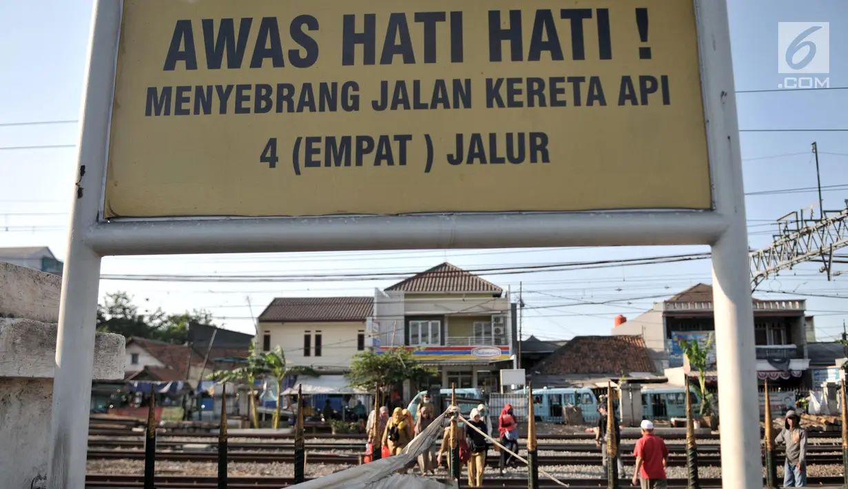 Warga menyeberangi perlintasan rel kereta api di kawasan Pisangan Baru, Jakarta, Selasa (10/9/2019). Mereka nekat menantang maut menyeberangi rel di dekat stasiun Jatinegara tersebut lantaran tidak adanya akses jembatan penyeberangan orang (JPO). (merdeka.com/Iqbal Nugroho)