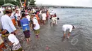 Sejumlah Umat Hindu melakukan ritual pengambilan air suci dari air laut saat mengikuti upacara Melasti menjelang Hari Raya Nyepi Tahun Saka 1937 di pantai Dupa, Palu, Sulawesi Tengah, Kamis (19/3/2015). (Liputan6.com/Dio Pratama)