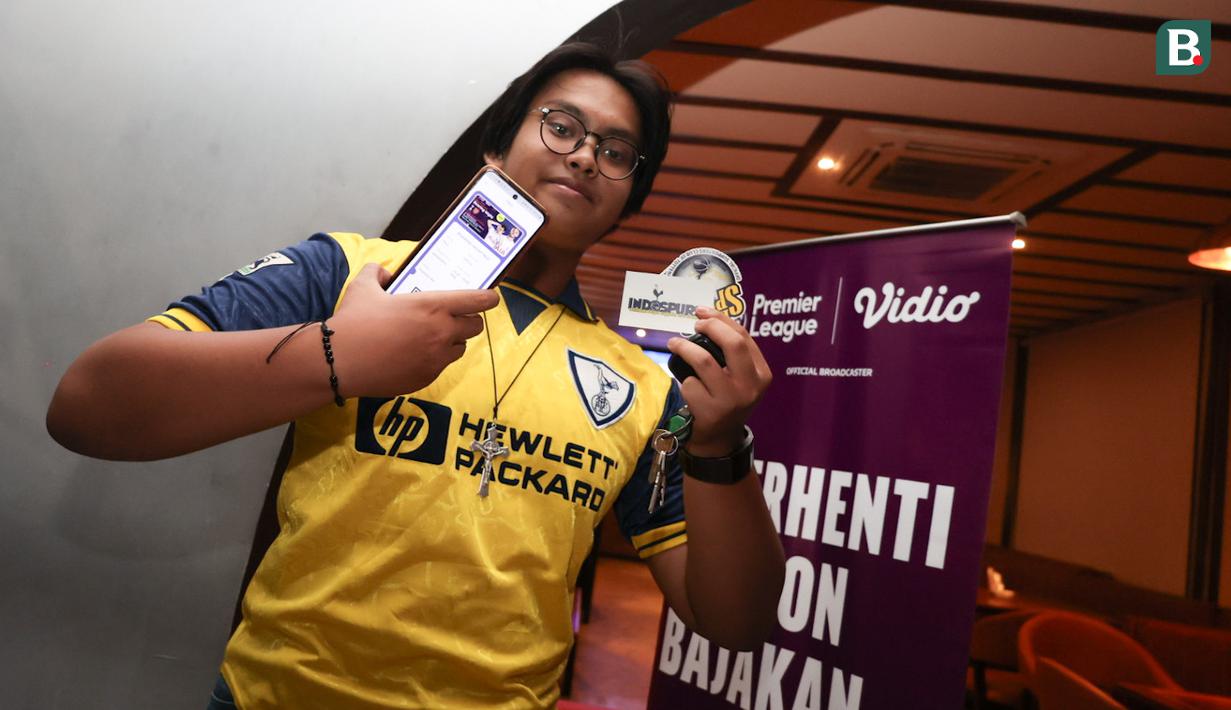 Seorang penggemar Tottenham Hotspur memperlihatkan aplikasi Youniverse yang digunakan untuk mengikuti nonton bareng Roaring Night Liga Inggris 2023/2024 antara Tottenham Hotspur kontra Arsenal di Treehaus Kemang, Minggu (28/4/2024) malam WIB yang digelar komunitas penggemar Tottenham Hotspur, IndoSpurs Jakarta. (Bola.com/Abdul Aziz)