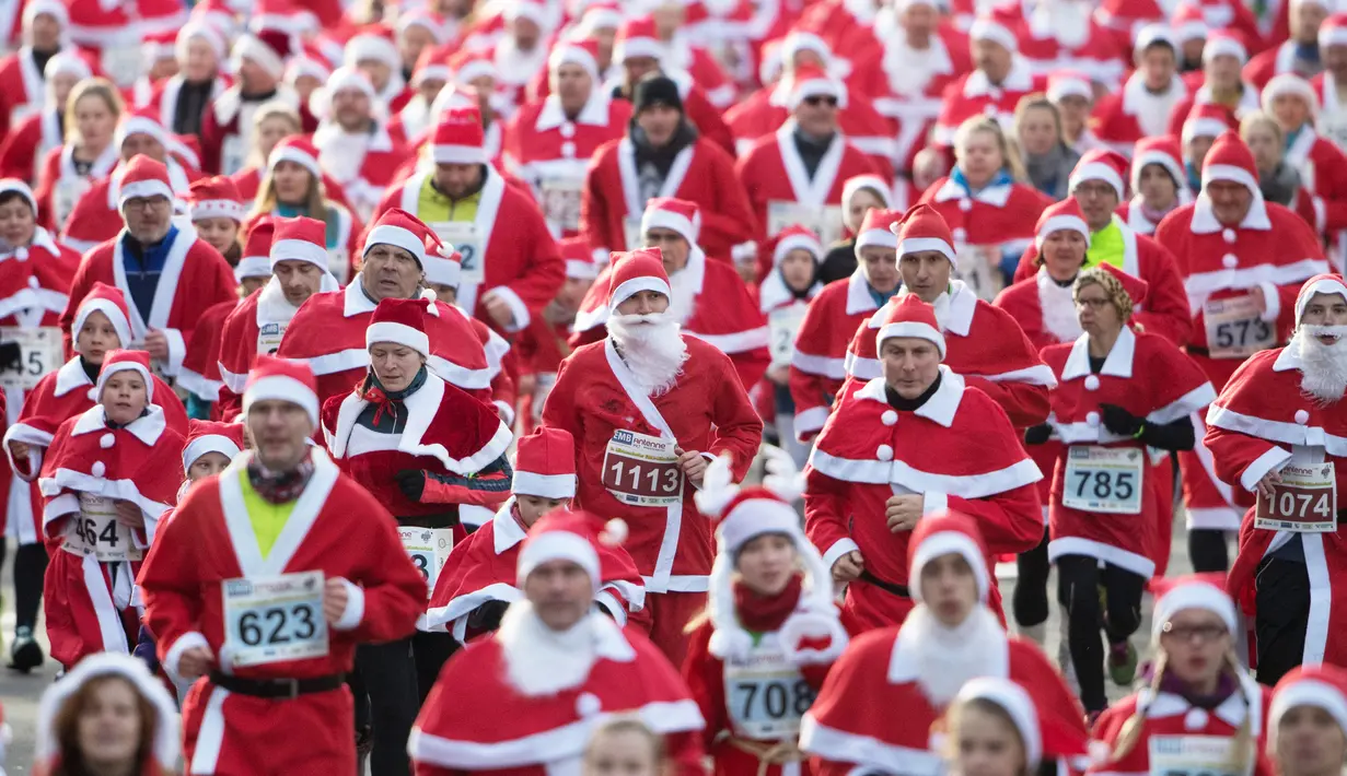 Para peserta mengenakan kostum Santa Claus berpartisipasi dalam Santa Claus Run di Michendorf, Jerman timur, Minggu (10/12). Kegiatan yang menjadi tradisi umat Kristiani ini diikuti mulai dari orang tua, hingga anak-anak. (Ralf Hirschberger / dpa / AFP)