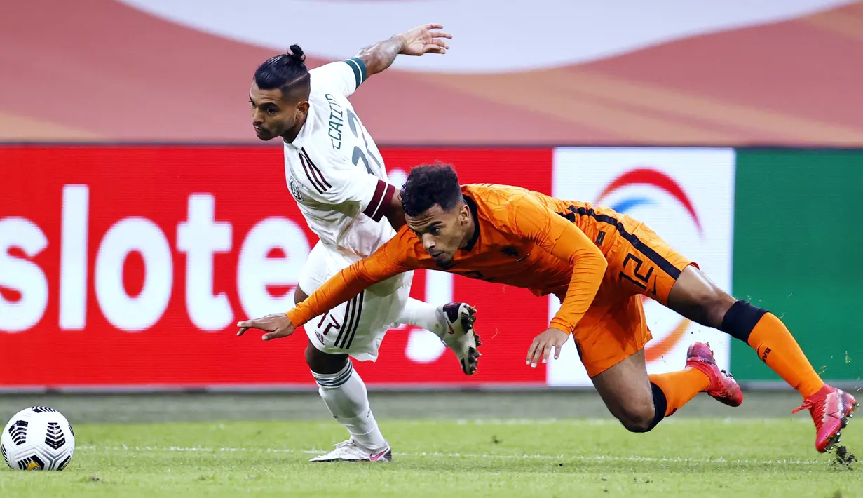 Penyerang Meksiko, Jesus Manuel Corona berebut bola dengan bek Belanda, Owen Wijndal pada laga persahabatan di Johan Cruyff Arena di Amsterdam (7/10/2020). Meksiko menang 1-0 atas Belanda. (AFP/ANP/Maurice Van Steen)