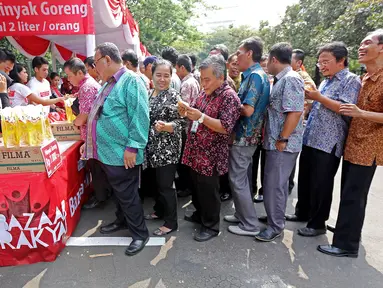 Pegawai antri untuk membeli minyak goreng murah Bazar Rakyat di lapangan parkir Kemenlu, Jakarta. (19/08). Sekitar 2.000 liter minyak goreng kemasan seharga Rp 7.000 per liter disalurkan bagi keluarga besar Kemenlu. (Liputan6.com/Angga Yuniar)
