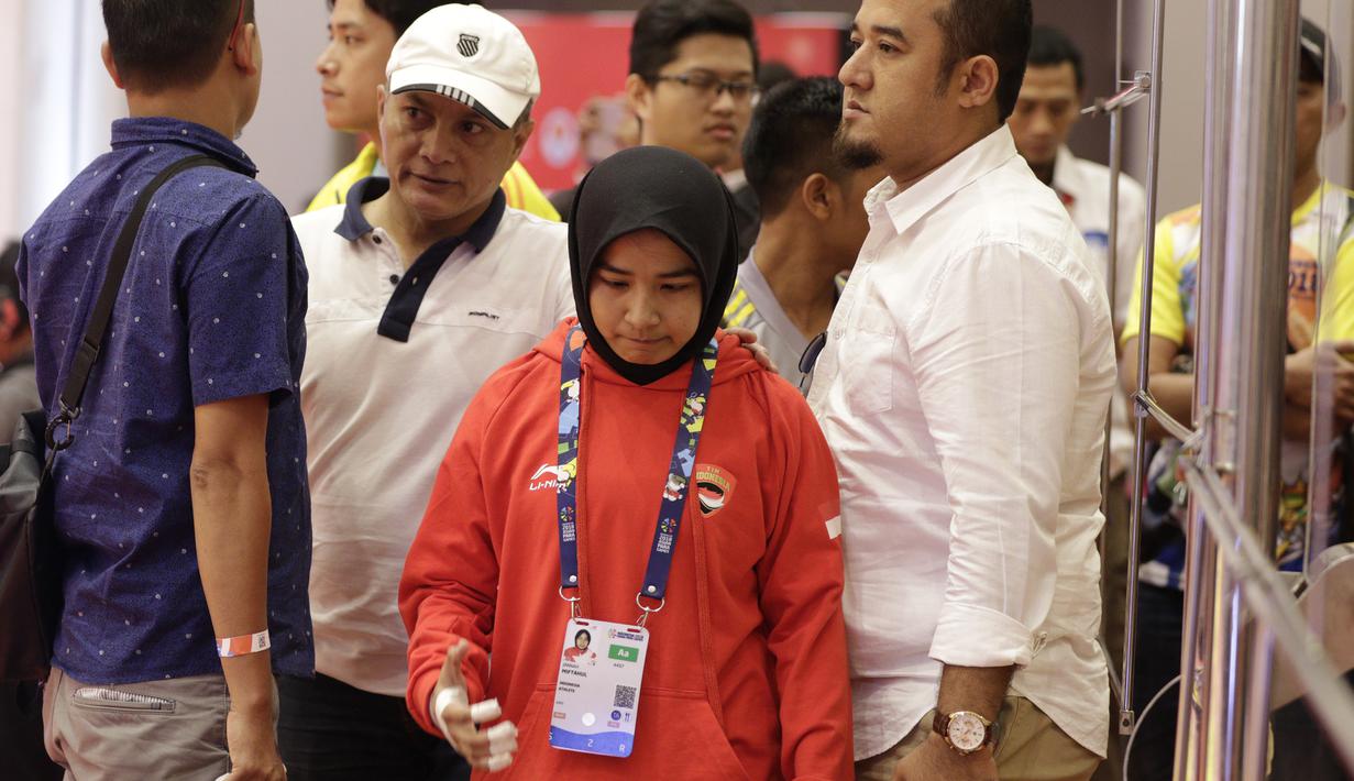 Atlet Judo Indonesia, Miftahul Jannah, meninggalkan lokasi pertandingan usai gagal berlaga pada Asian Para Games di Jiexpo, Kemayoran, Jakarta, Senin (8/10/2018). Miftah didiskualifikasi karena enggan melepas hijab nya. (Bola.com/M Iqbal Ichsan)
