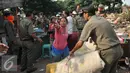 Warga dibantu petugas mengevakuasi barang saat penggusuran di kawasan TPU Menteng Pulo, Jakarta Selatan (7/4). Lebih dari seratus kepala keluarga digusur karena menempati lahan dan mendirikan bangunan di pemakaman umum. (Liputan6.com/Gempur M Surya)