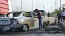 Seorang remaja melihat mobil yang hancur akibat bom di Ameriyat Falluja, Irak, Jumat (18/11). Mobil tersebut sengaja dijadikan bom yang diduga dilakukan oleh kelompok ISIS. (Reuters/Osamah Waheeb) 
