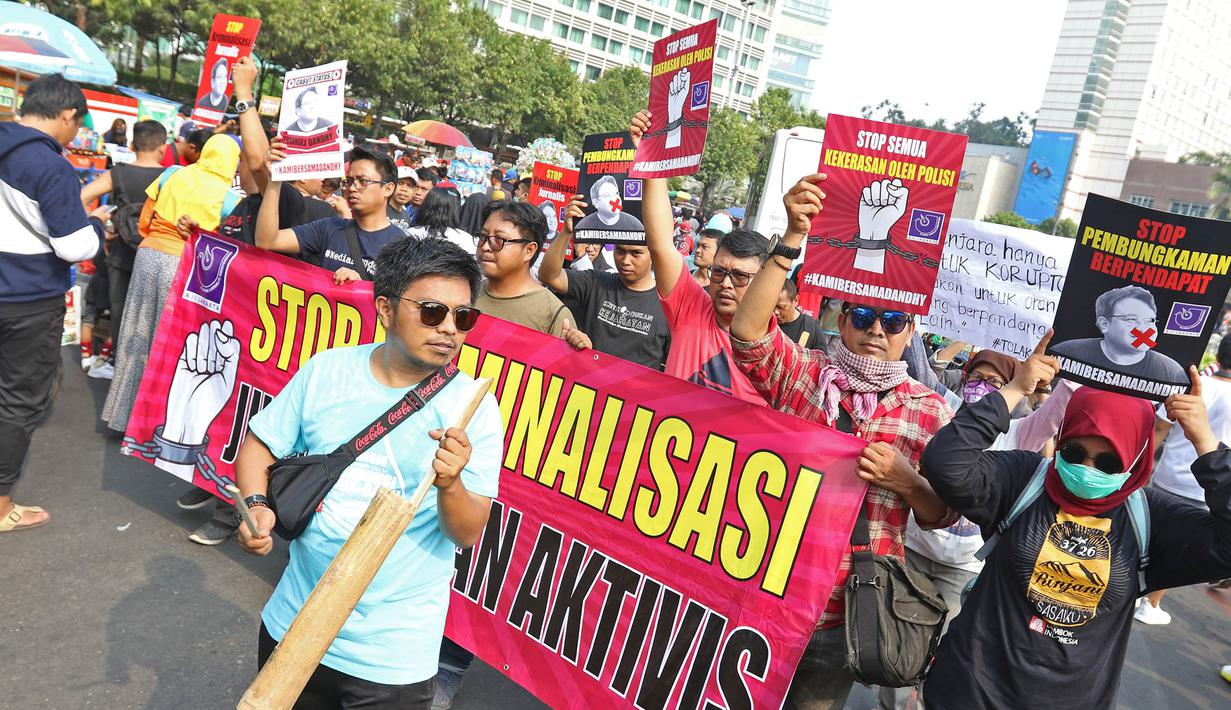 Jurnalis yang tergabung dalam Aliansi Jurnalis Independen (AJI) menggelar aksi jalan mundur saat Car Free Day di Bundaran HI, Jakarta, Minggu (29/9/2019). Kegiatan tersebut bentuk desakan agar Polda Metro Jaya mencabut status tersangka jurnalis Dandhy Dwi Laksono. (Liputan6.com/Herman Zakharia)