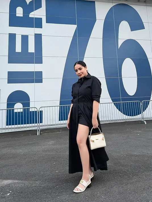 Setelah menyaksikan sang suami tampil, Nagita menghadiri fashion show Spring Summer 2023 dari Tory Burch. Ia mengenakan dress hitam dengan detail belahan tinggi pada roknya yang menampilkan short pants hitam sebagai inner-nya. Diketahui, dress dengan nama cotton poplin eleanor ini ditaksir seharga Rp11 jutaan. (Instagram/raffinagita1717).