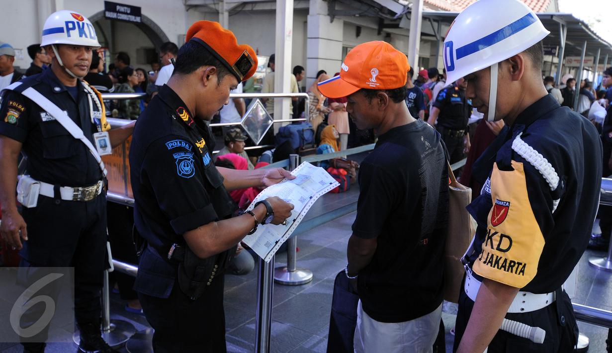 Petugas mengecek kecocokan data karcis dengan identitas pemudik di Stasiun Senen Jakarta, Sabtu (2/7). Ribuan pemudik kembali memadati Stasiun Senen untuk berangkat menuju kota kota di pulau Jawa. (Liputan6.com/Helmi Fithriansyah)