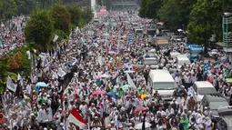 Ribuan peserta aksi damai 2 Desember berjalan kaki sambil berorasi‎ menyusuri Jalan MH Thamrin, Jakarta, Jumat (2/12). Usai melaksanakan salat jumat, massa yang memenuhi dua jalur MH Thamrin itu berjalan kaki menuju Bundaran HI (Liputan6.com/Fery Pradolo)