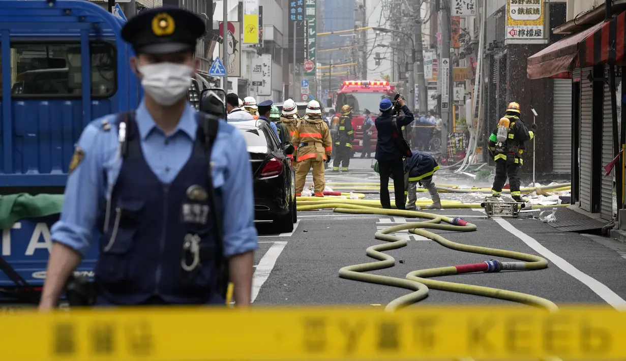 <p>Petugas pemadam kebakaran dan polisi bekerja di lokasi ledakan di sebuah gedung di Tokyo, Jepang, Senin (3/7/2023). Sebanyak empat orang terluka akibat kejadian tersebut. (AP Photo/Eugene Hoshiko)</p>