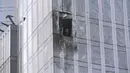 Seorang penyelidik memeriksa gedung pencakar langit yang rusak di kawasan bisnis Kota Moskow setelah laporan serangan pesawat tak berawak atau drone di Moskow, Rusia, Rabu (23/8/2023). (AP Photo)