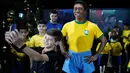 Seorang anak berswafoto dengan patung pemain sepak bola legendaris Brasil, Pele, di Museum Tim Sepak Bola Brasil di Rio de Janeiro, Kamis (20/2/2020). Konfederasi Sepak Bola Brasil meluncurkan patung Pele sebagai bagian dari peringatan 50 tahun sejak kemenangan Piala Dunia 1970. (AP/Leo Correa)