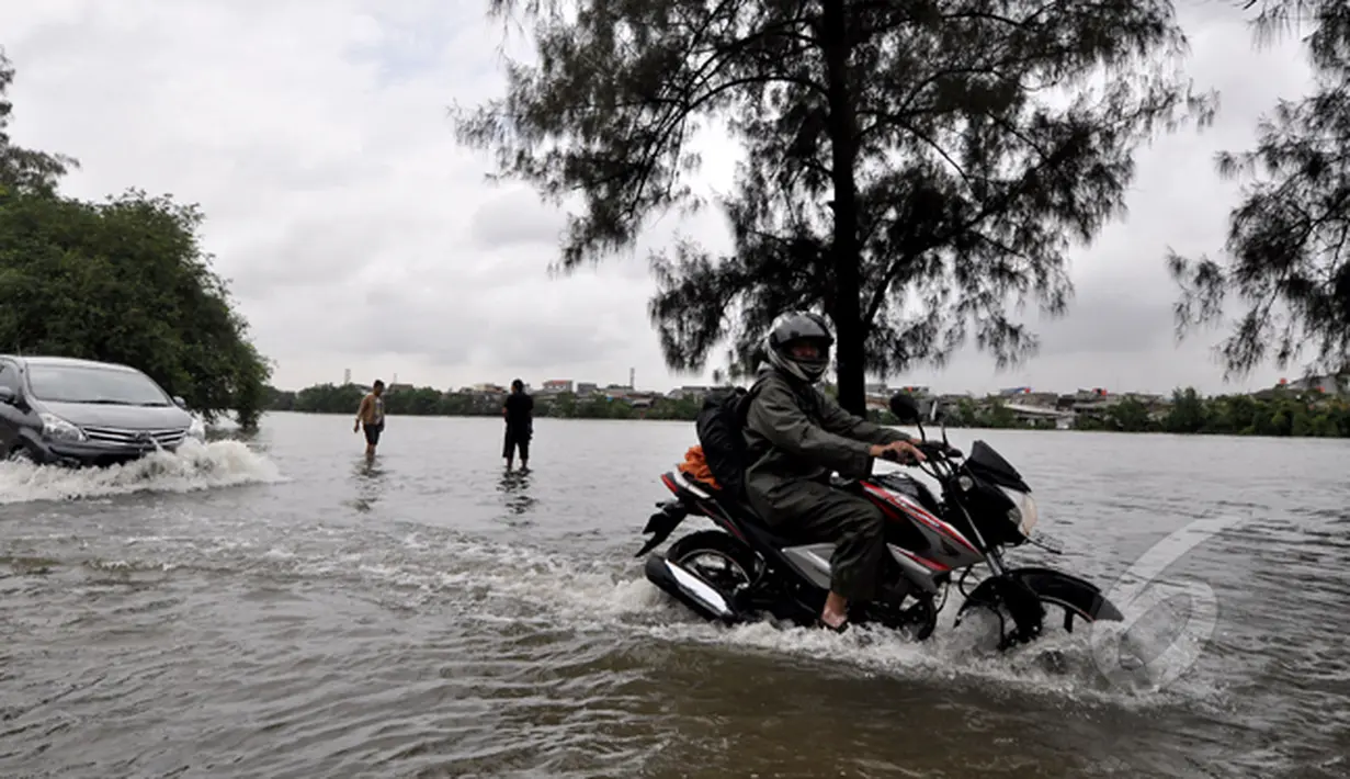 Curah hujan yang tinggi menyebabkan Danau Sunter tak mampu menampung debit air hingga meluap ke daerah sekitarnya. Tampak sejumlah kendaraan nekat menerobos banjir, Jakarta, Selasa (10/2/2015). (Liputan6.com/Faizal Fanani)