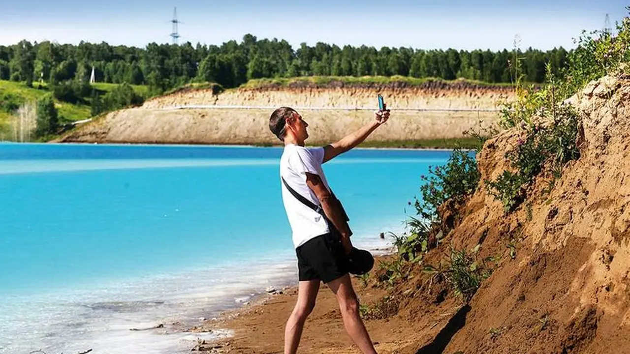 Seorang pria berswafoto di depan Novosibirsk Maldives, danau dengan air biru pekat yang dipuja pengguna Instagram di Rusia (AFP Photo)