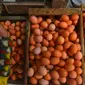 Penjual menunjukkan telur dagangannya di Pasar Minggu, Jakarta, Rabu (24/7). Harga telur ayam mengalami penurunan di angka Rp 26 ribu per kilo. (Merdeka.com/Imam Buhori)