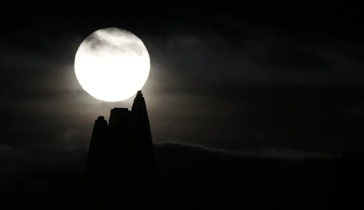 Bulan purnama yang dikenal sebagai Harvest moon muncul di atas Whitby Abbey, di Whitby, Inggris, Senin (20/9/2021). Bulan purnama Harvest Moon biasanya terjadi di bulan September, namun kadang juga terlambat hingga ke Oktober. (AP Photo/Alastair Grant)