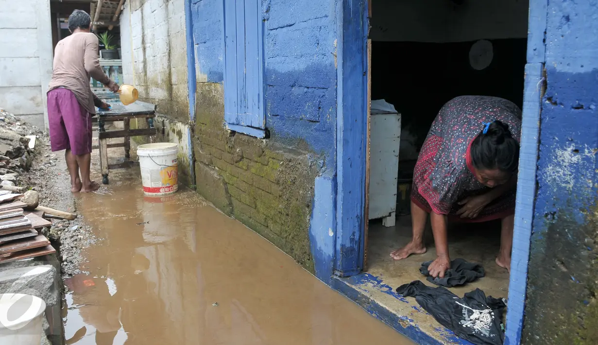 Warga mebersihkan sisa-sisa endapan lumpur di rumahnya, Cawang, Jakarta, Senin (7/11). Sebelumnya, ratusan rumah warga di RW 02 Cawang, Kramat Jati, Jakarta Timur tergenang akibat banjir kiriman dari kawasan Bogor. (Liputan6.com/Yoppy Renato)