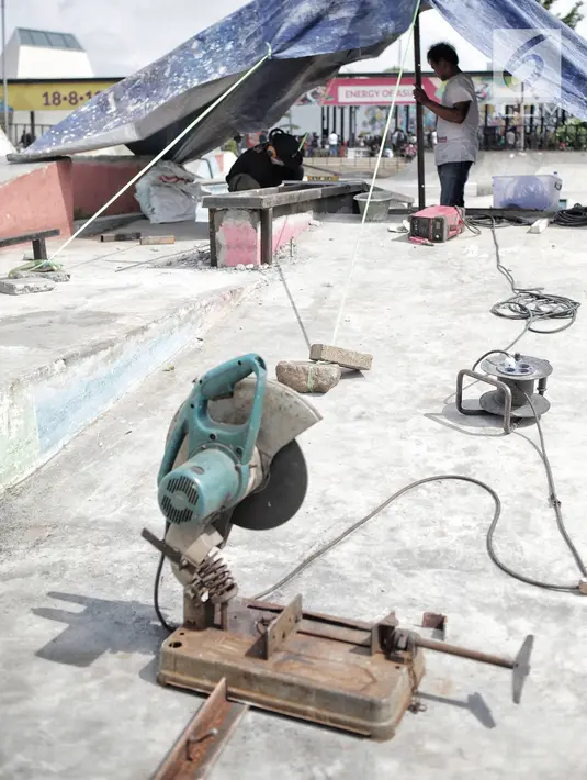 Pekerja memperbaiki arena skateboard yang rusak di RPTRA Kalijodo, Jakarta, Kamis (24/1). Perbaikan dilakukan untuk membuat rasa aman dan nyaman pengunjung yang menggunakan arena tersebut. (Liputan6.com/Faizal Fanani)