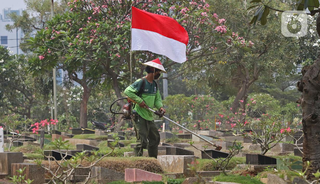 Petugas Pertamanan dan Kehutanan Kota Jakarta Pusat mengenakan atribut kemerdekaan saat memotong rumput di TPU Karet Bivak, Jakarta, Minggu (16/8/2020). Para petugas bekerja dengan mengenakan atribut kemerdekaan dalam rangka menyambut HUT ke-75 RI. (Liputan6.com/Herman Zakharia)