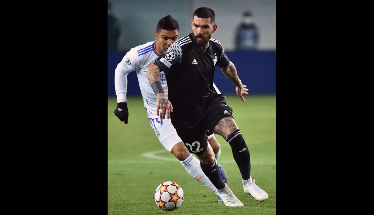 Pemain Sheriff Tiraspol, Dimitrios Kolovos (kanan) berebut bola dengan pemain Real Madrid, Casemiro pada laga Liga Champions 2021/2022 di Sheriff Stadium, Tiraspol, 24 November 2021. (AFP/Sergei Gapon)