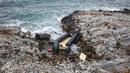 Sebuah perahu karet, yang diyakini digunakan oleh para migran, hancur di garis pantai berbatu, di Thermi di pulau Lesbos Yunani pada 7 Februari 2023. Sebuah kapal yang membawa migran dari negara tetangga Turki tenggelam di lepas pantai. (Manolis Lagoutaris / AFP)