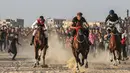 Sejumlah joki memacu kudanya saat bersaing dalam balap kuda di Rafah, Jalur Gaza, Palestina, Selasa (10/9/2019). Balapan kuda tradisional Palestina tersebut digelar di bekas lokasi bandara Jalur Gaza yang telah hancur. (AFP Photo/Said Khatib)