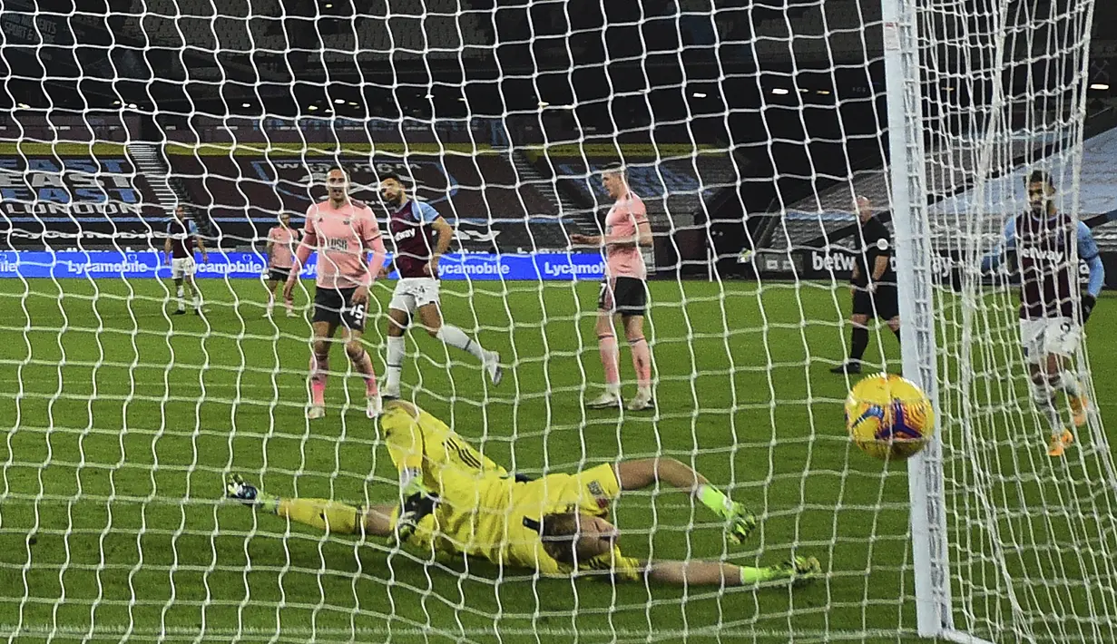 Kiper Sheffield United, Aaron Ramsdale kebobolan gol ketiga oleh bek West Ham United, Ryan Fredericks dalam laga lanjutan Liga Inggris 2020/21 pekan ke-24 di London Stadium, London, Senin (15/2/2021). Sheffield United kalah 0-3 dari West Ham. (AP/Glyn Kirk/Pool)