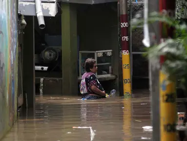 Aktivitas warga Kebon Pala, Kampung Melayu Jakarta Timur di tengah banjir akibat luapan kali Ciliwung, Selasa (2/7/2024). (merdeka.om/Imam Buhori)