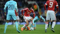 Pemain Manchester United, Marouane Fellaini berebut bola dengan pemain PSV Eindhoven, Andres Guardado pada lanjutan liga Champions grup B di Stadion Old Trafford, Manchester, Kamis (26/11/2015) dini hari WIB. (AFP Photo/Oli Scarff)