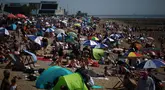 Orang-orang bersantai di kawasan Southend-on-Sea, bagian tenggara Inggris pada 12 Agustus 2024. (HENRY NICHOLLS/AFP)