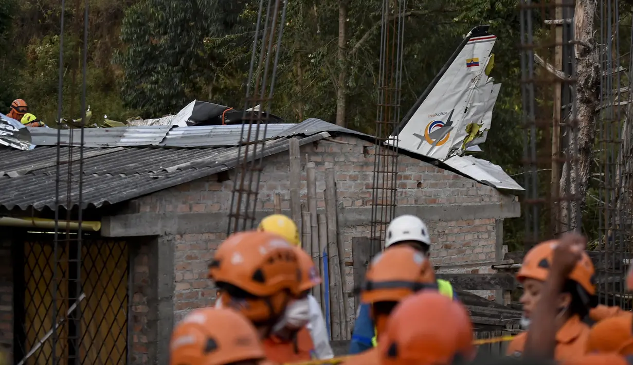 Tim penyelamat berada di lokasi jatuhnya sebuah pesawat kecil di tengah-tengah rumah penduduk di Popayan, Kolombia, Minggu (15/9/2019). Insiden tersebut mengakibatkan tujuh dari sembilan penumpang tewas. (Luis ROBAYO / AFP)