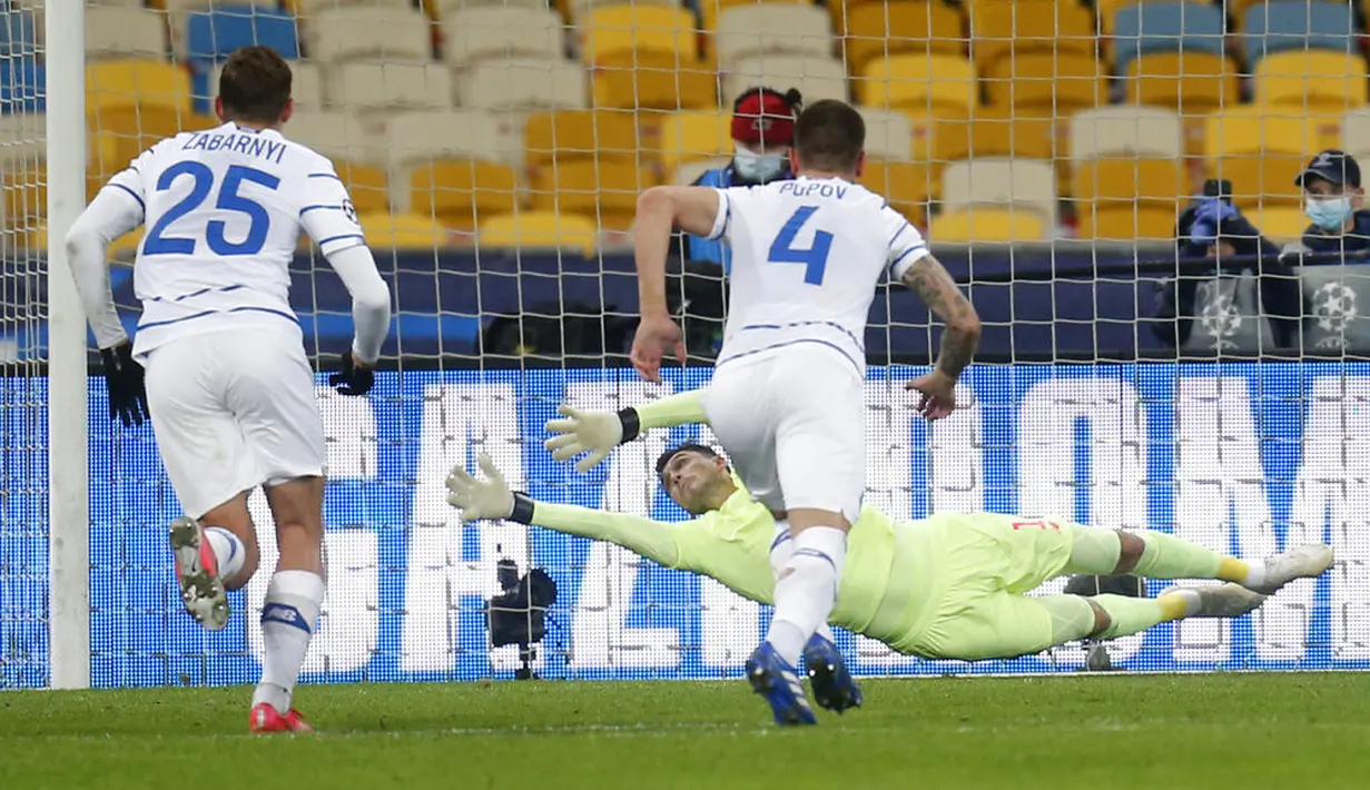 Penjaga gawang Dynamo Kyiv Heorhiy Bushchan gagal menyelamatkan bola saat pemain Barcelona Martin Braithwaite mencetak gol ke gawangnya pada pertandingan Grup G Liga Champions di Stadion Olimpiyskiy, Kyiv, Ukraina, Selasa (24/11/2020). Barcelona membantai Dynamo Kyiv 4-0. (AP Photo/Efrem Lukatsky)