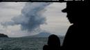 Personel TNI Angkatan Laut menyaksikan Gunung Anak Krakatau yang memuntahkan material vulkanik di perairan Selat Sunda (28/12). Pihak berwenang mengatakan pencarian korban terdampak tsunami akan berlanjut hingga Januari. (AP Photo/Fauzy Chaniago)