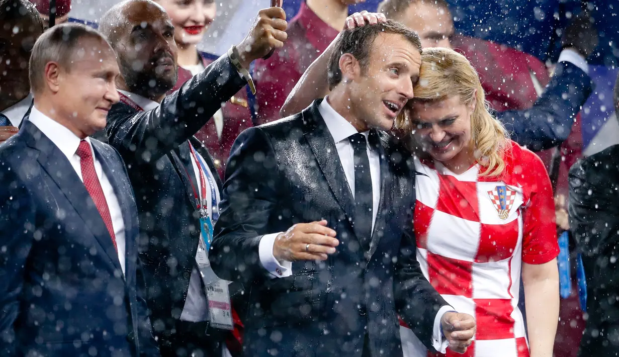 Presiden Rusia Vladimir Putin (kiri) melihat ke arah Presiden Prancis Emmanuel Macron (tengah) dan Presiden Kroasia Kolinda Grabar-Kitarovic usai laga final Piala Dunia 2018 di Stadion Luzhnik, Moskow, Rusia, Minggu (15/7). (AP Photo/Petr David Josek)