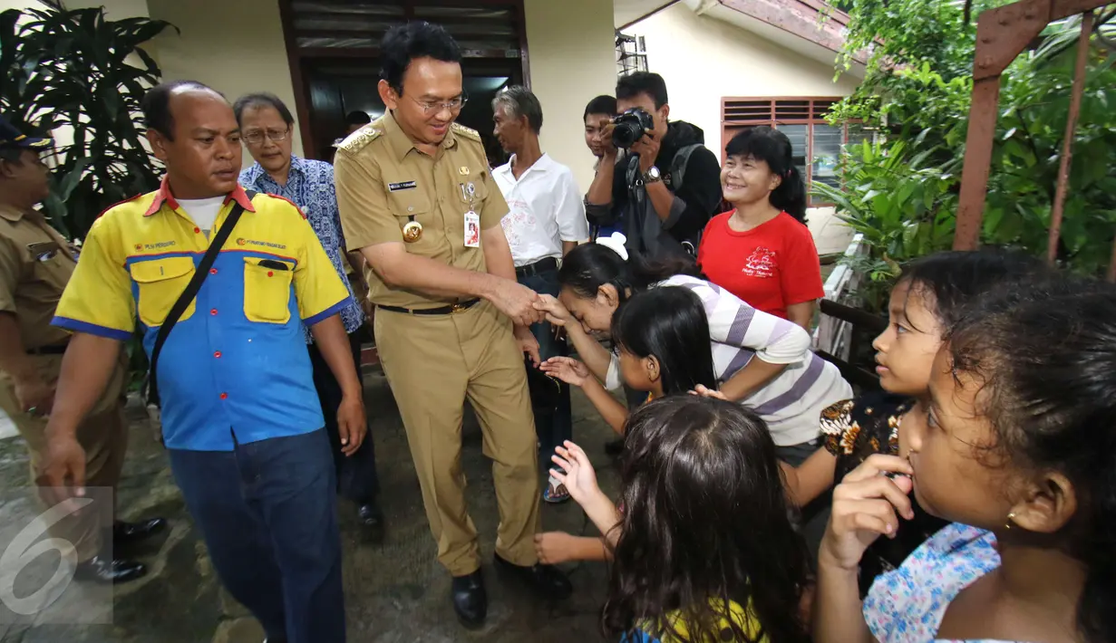 Ahok bersalaman dengan warga saat blusukan di Bukit Duri, Jakarta, Senin (20/2). Ahok juga menyempatkan diri untuk berinteraksi dan berdialog dengan warga terkait banjir yang sering melanda. (Liputan6.com/Helmi Afandi)