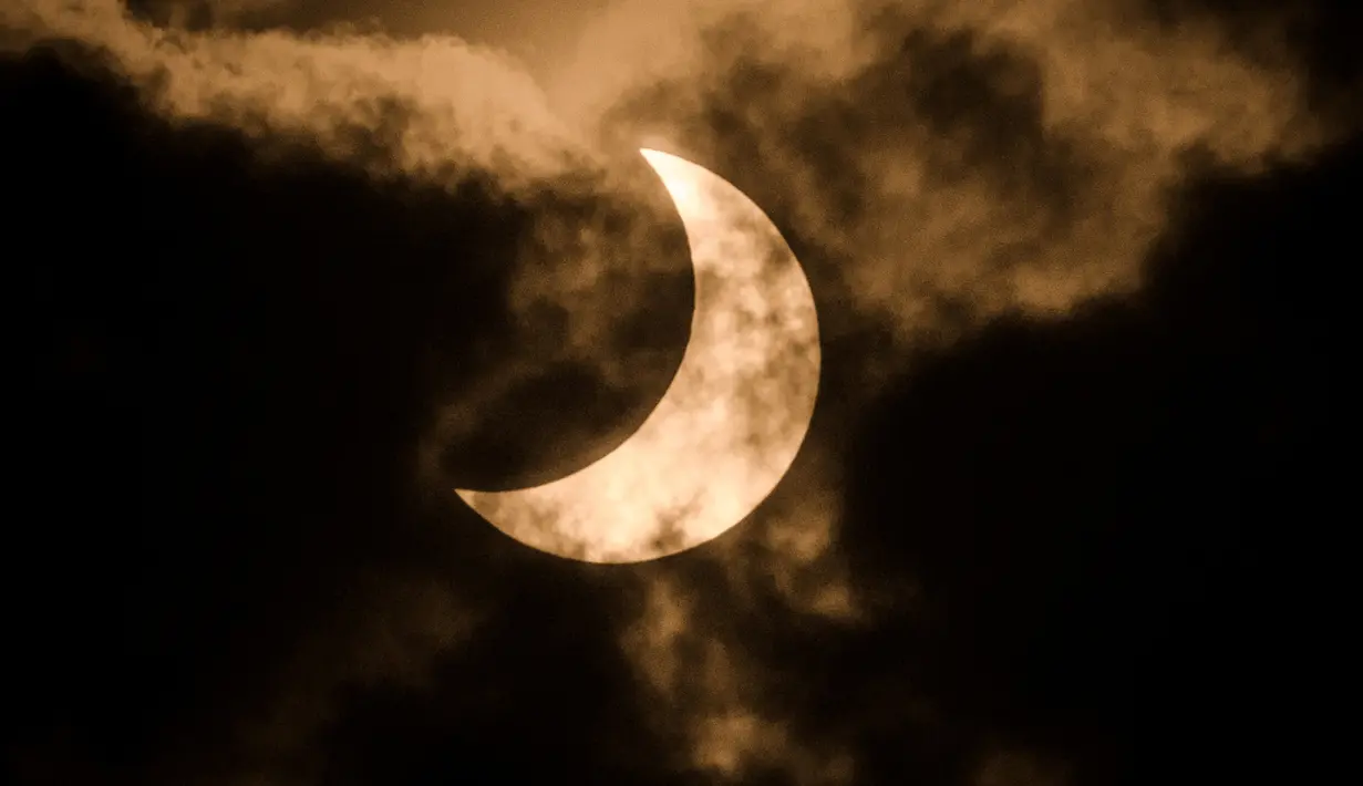 Gerhana matahari parsial diambil menggunakan filter infra merah di langit berawan Nairobi, Kenya, Minggu (21/6/2020). Dunia menikmati Gerhana Matahari Cincin dan Gerhana Matahari Sebagian pada Minggu 21 Juni 2020. (YASUYOSHI CHIBA / AFP)