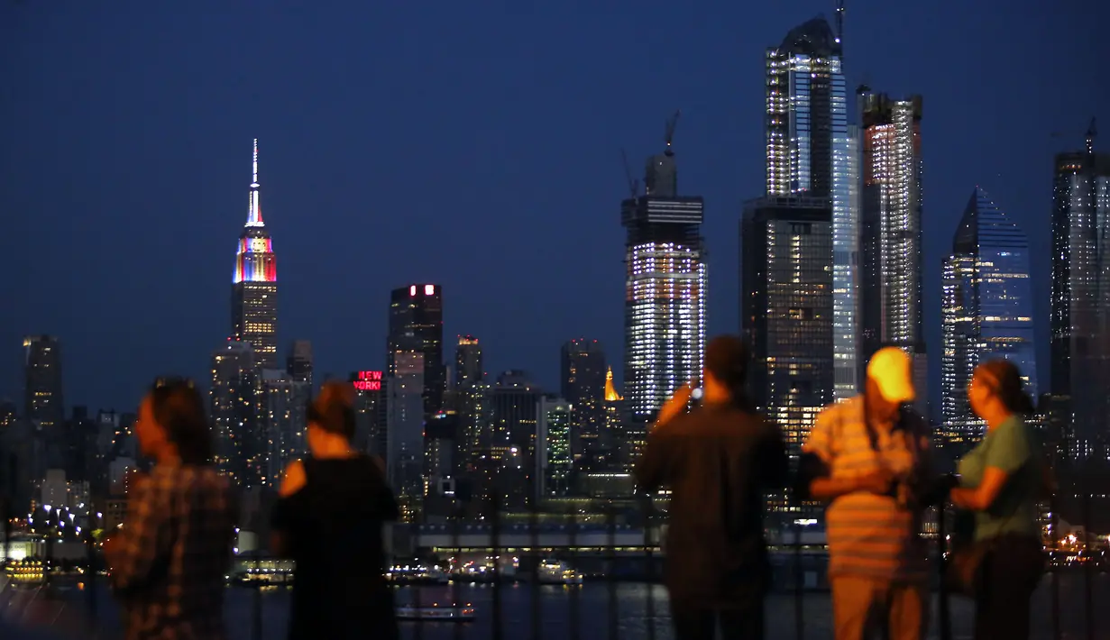 Gedung pencakar langit Empire State di New York memancarkan lampu warna bendera juara Piala Dunia 2018, Prancis, Minggu (15/7). Sebelumnya, pucak gedung terkenal di Amerika Serikat itu selalu menyalakan warna putih. (AFP PHOTO / KENA BETANCUR)